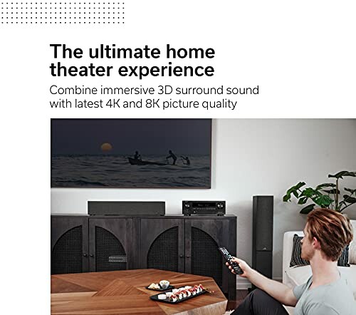 Person using remote for home theater system with TV and speakers.